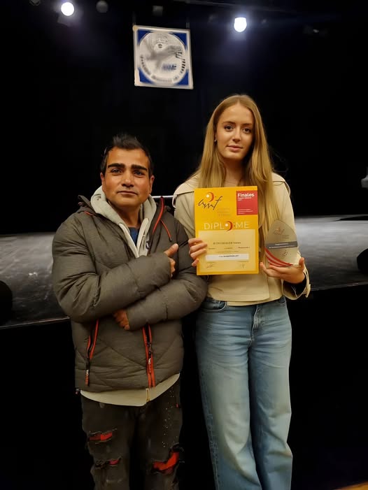 Jean Reinhart tenant un diplôme dans son studio de batterie